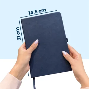 Agenda 2027 CARAVIAN PRO Azul con bolígrafo en mano, medidas 14.5 x 21 cm